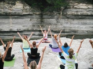 Women doing group yoga on the sand